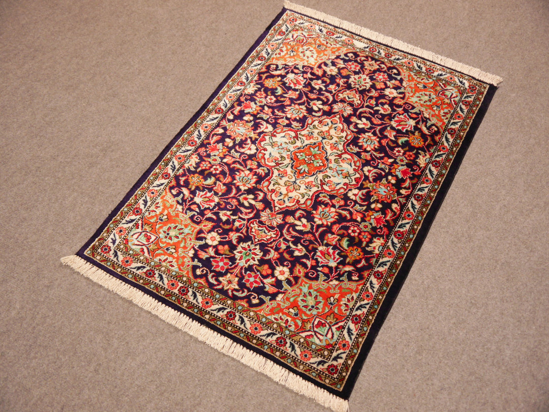 Close-up of ultra-fine 1,000,000 knots per sqm weave of a Ghom silk rug, showing intricate floral details.
