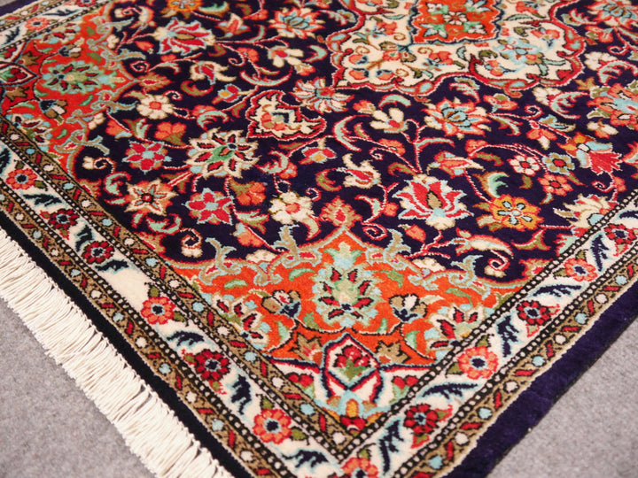 Close-up of ultra-fine 1,000,000 knots per sqm weave of a Ghom silk rug, showing intricate floral details.