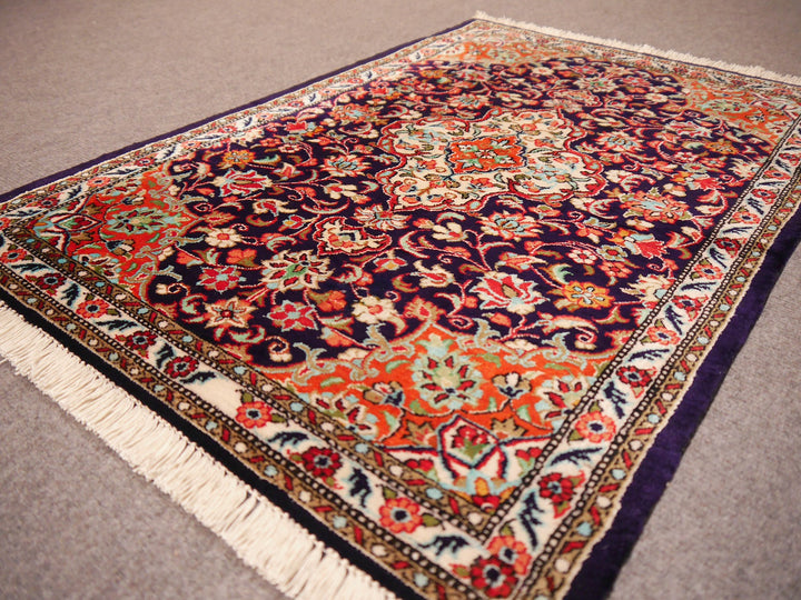 Close-up of ultra-fine 1,000,000 knots per sqm weave of a Ghom silk rug, showing intricate floral details.