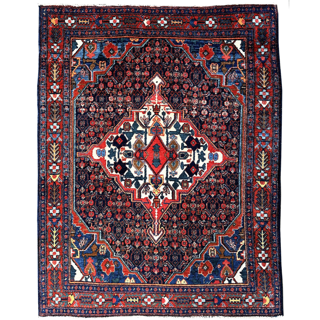 A hand - knotted antique Persian Senneh Sanandaj rug with a blue field, red border and ivory medaillon. Very good overall condition, equally even pile, fringes newly secured and original shirazi. Beautiful collectors piece, kurdish traditional carpet.