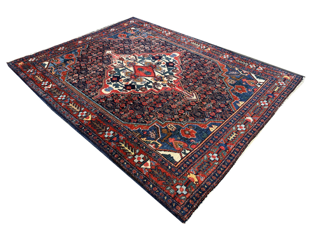 A hand - knotted antique Persian Senneh Sanandaj rug with a blue field, red border and ivory medaillon. Very good overall condition, equally even pile, fringes newly secured and original shirazi. Beautiful collectors piece, kurdish traditional carpet.