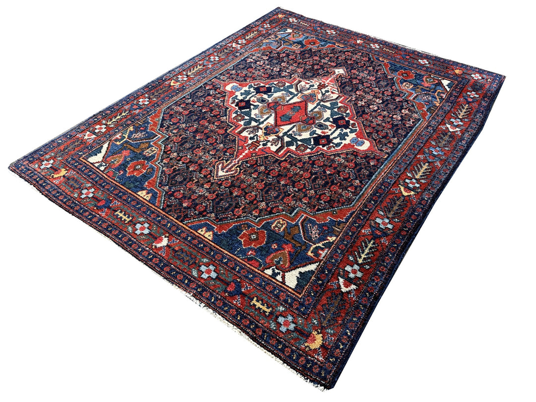 A hand - knotted antique Persian Senneh Sanandaj rug with a blue field, red border and ivory medaillon. Very good overall condition, equally even pile, fringes newly secured and original shirazi. Beautiful collectors piece, kurdish traditional carpet.