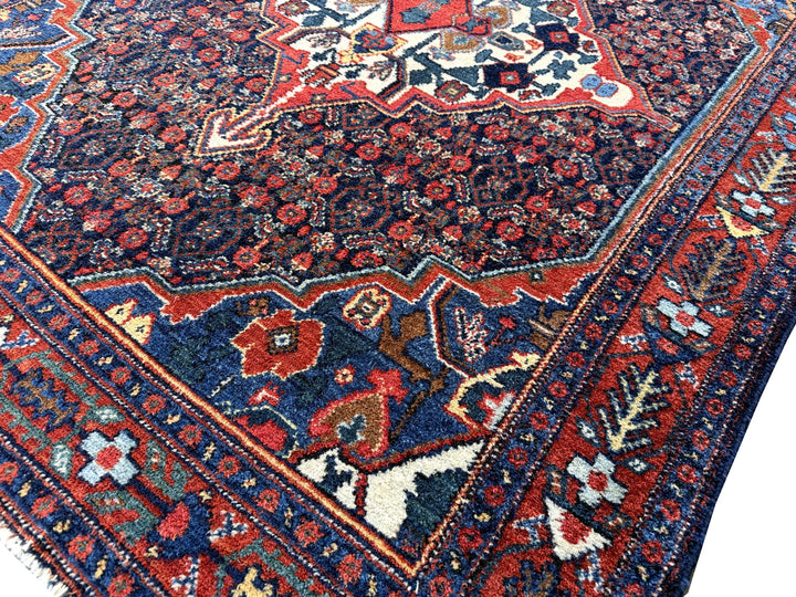 A hand - knotted antique Persian Senneh Sanandaj rug with a blue field, red border and ivory medaillon. Very good overall condition, equally even pile, fringes newly secured and original shirazi. Beautiful collectors piece, kurdish traditional carpet.