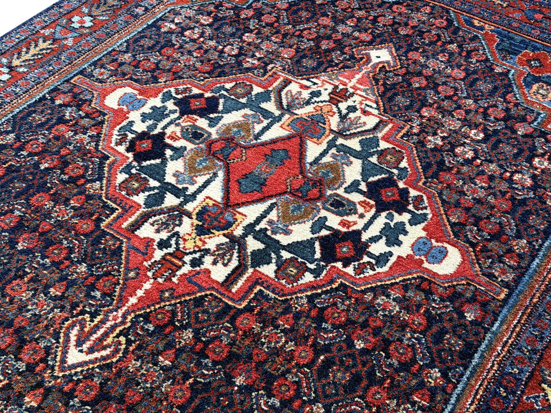 A hand - knotted antique Persian Senneh Sanandaj rug with a blue field, red border and ivory medaillon. Very good overall condition, equally even pile, fringes newly secured and original shirazi. Beautiful collectors piece, kurdish traditional carpet.