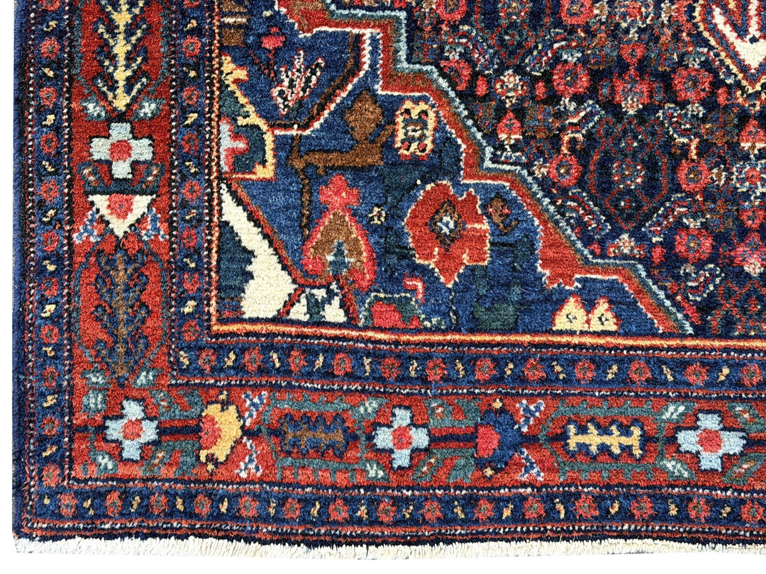 A hand - knotted antique Persian Senneh Sanandaj rug with a blue field, red border and ivory medaillon. Very good overall condition, equally even pile, fringes newly secured and original shirazi. Beautiful collectors piece, kurdish traditional carpet.