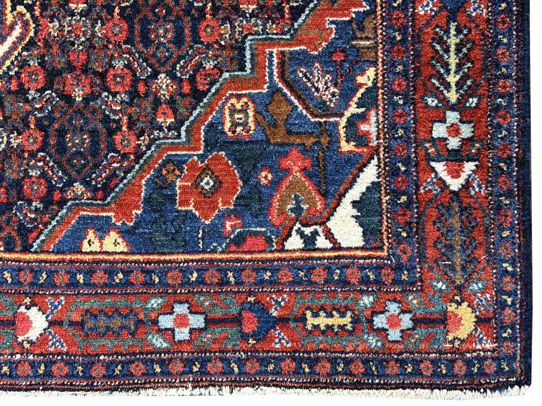 A hand - knotted antique Persian Senneh Sanandaj rug with a blue field, red border and ivory medaillon. Very good overall condition, equally even pile, fringes newly secured and original shirazi. Beautiful collectors piece, kurdish traditional carpet.