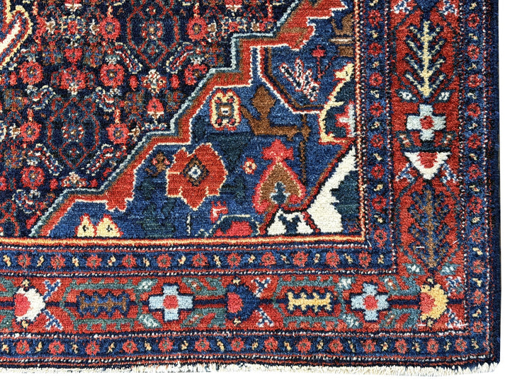 A hand - knotted antique Persian Senneh Sanandaj rug with a blue field, red border and ivory medaillon. Very good overall condition, equally even pile, fringes newly secured and original shirazi. Beautiful collectors piece, kurdish traditional carpet.