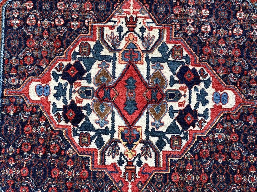 A hand - knotted antique Persian Senneh Sanandaj rug with a blue field, red border and ivory medaillon. Very good overall condition, equally even pile, fringes newly secured and original shirazi. Beautiful collectors piece, kurdish traditional carpet.