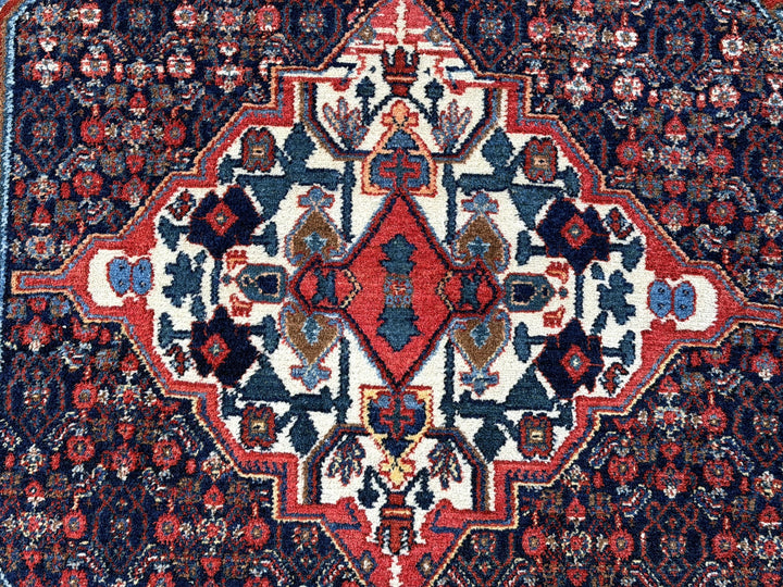 A hand - knotted antique Persian Senneh Sanandaj rug with a blue field, red border and ivory medaillon. Very good overall condition, equally even pile, fringes newly secured and original shirazi. Beautiful collectors piece, kurdish traditional carpet.