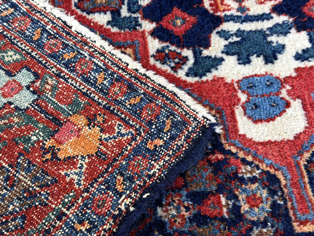A hand - knotted antique Persian Senneh Sanandaj rug with a blue field, red border and ivory medaillon. Very good overall condition, equally even pile, fringes newly secured and original shirazi. Beautiful collectors piece, kurdish traditional carpet.