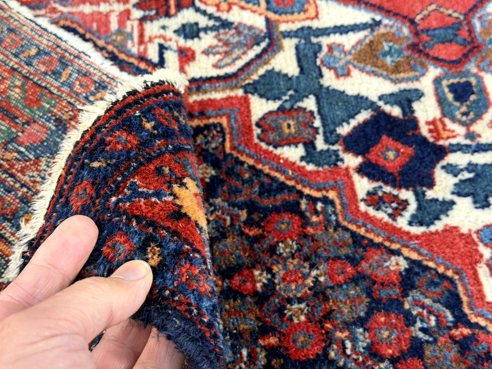 A hand - knotted antique Persian Senneh Sanandaj rug with a blue field, red border and ivory medaillon. Very good overall condition, equally even pile, fringes newly secured and original shirazi. Beautiful collectors piece, kurdish traditional carpet.