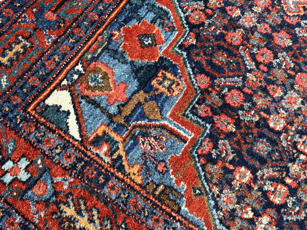 A hand - knotted antique Persian Senneh Sanandaj rug with a blue field, red border and ivory medaillon. Very good overall condition, equally even pile, fringes newly secured and original shirazi. Beautiful collectors piece, kurdish traditional carpet.