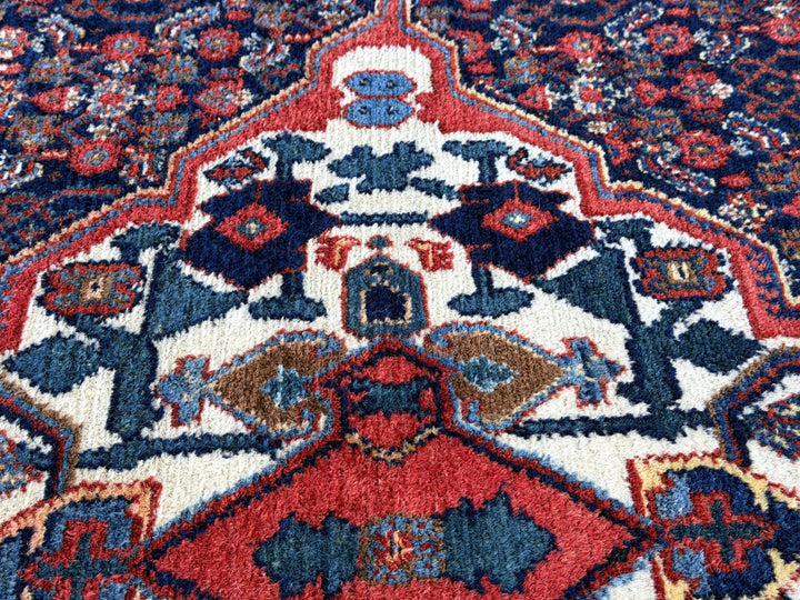 A hand - knotted antique Persian Senneh Sanandaj rug with a blue field, red border and ivory medaillon. Very good overall condition, equally even pile, fringes newly secured and original shirazi. Beautiful collectors piece, kurdish traditional carpet.