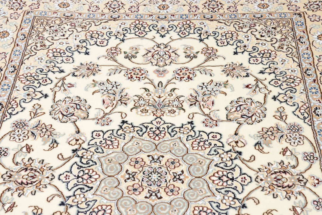 This fine, Persian rug is a typical piece in the popular traditional Nain design. The colors are a wool white field, beige border and light blue accents. The size is 203 x 132 cm, the quality is 9la. The round Medaillon is floral like the field and corners.