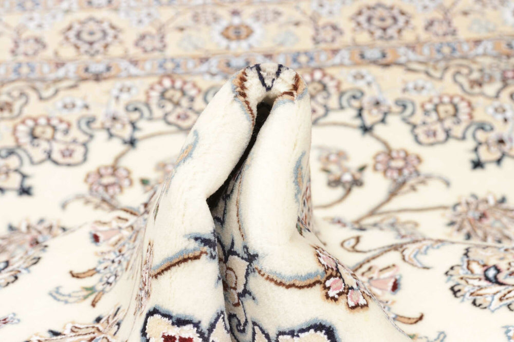 This fine, Persian rug is a typical piece in the popular traditional Nain design. The colors are a wool white field, beige border and light blue accents. The size is 203 x 132 cm, the quality is 9la. The round Medaillon is floral like the field and corners.