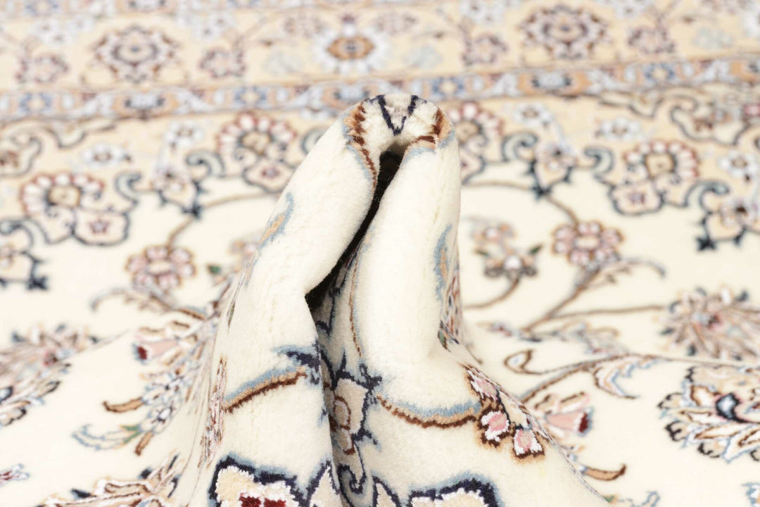 This fine, Persian rug is a typical piece in the popular traditional Nain design. The colors are a wool white field, beige border and light blue accents. The size is 203 x 132 cm, the quality is 9la. The round Medaillon is floral like the field and corners.
