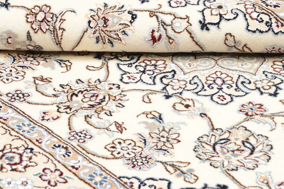 This fine, Persian rug is a typical piece in the popular traditional Nain design. The colors are a wool white field, beige border and light blue accents. The size is 203 x 132 cm, the quality is 9la. The round Medaillon is floral like the field and corners.