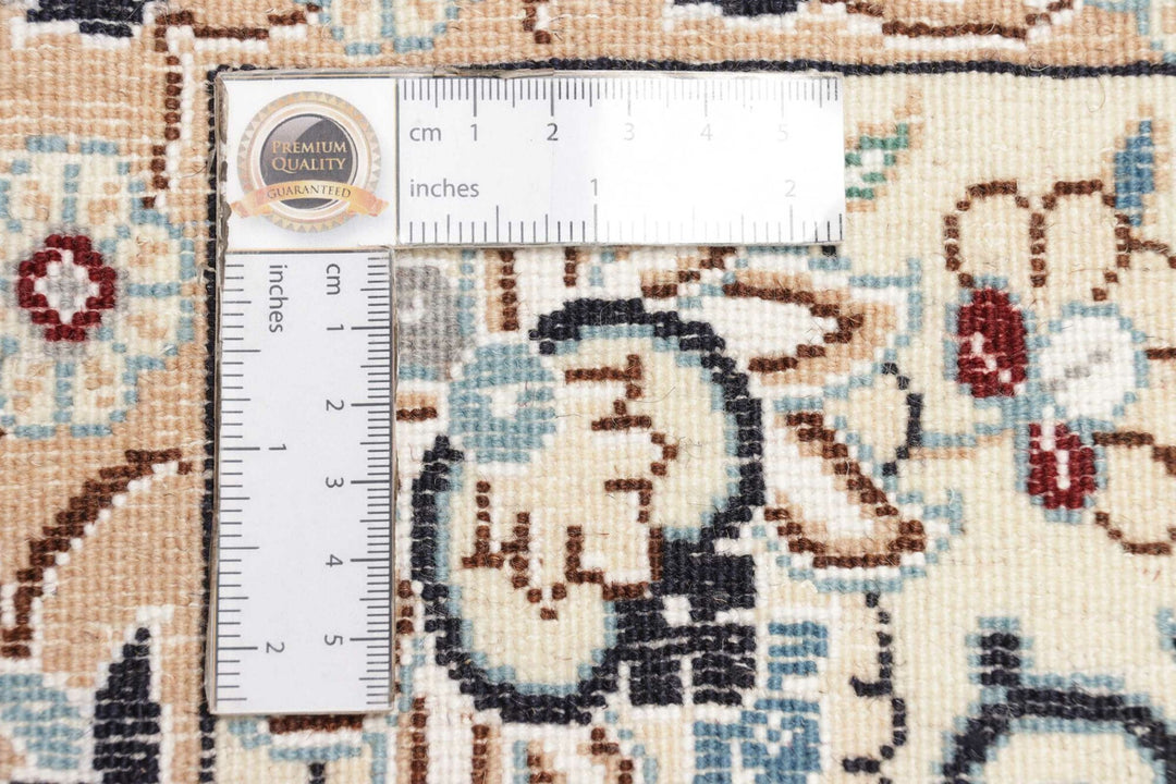 This fine, Persian rug is a typical piece in the popular traditional Nain design. The colors are a wool white field, beige border and light blue accents. The size is 203 x 132 cm, the quality is 9la. The round Medaillon is floral like the field and corners.